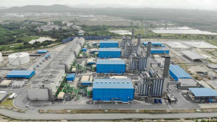Aerial view of a power station complex with blue-roofed buildings
