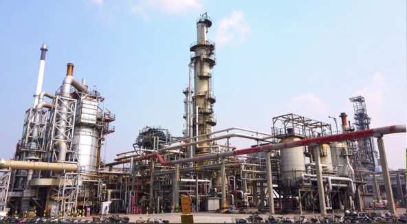 Refinery process columns and piping under a blue sky
