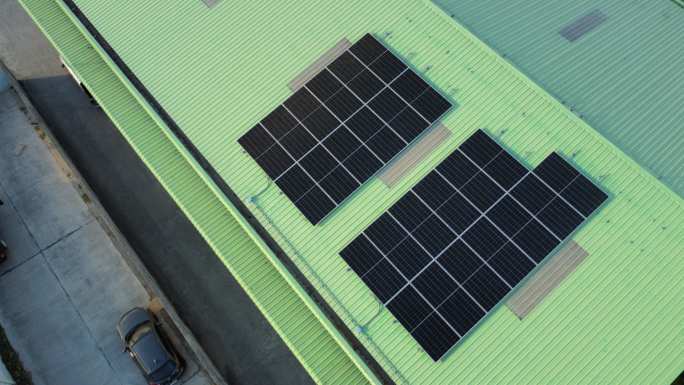 Solar panels on a green industrial roof, seen from above