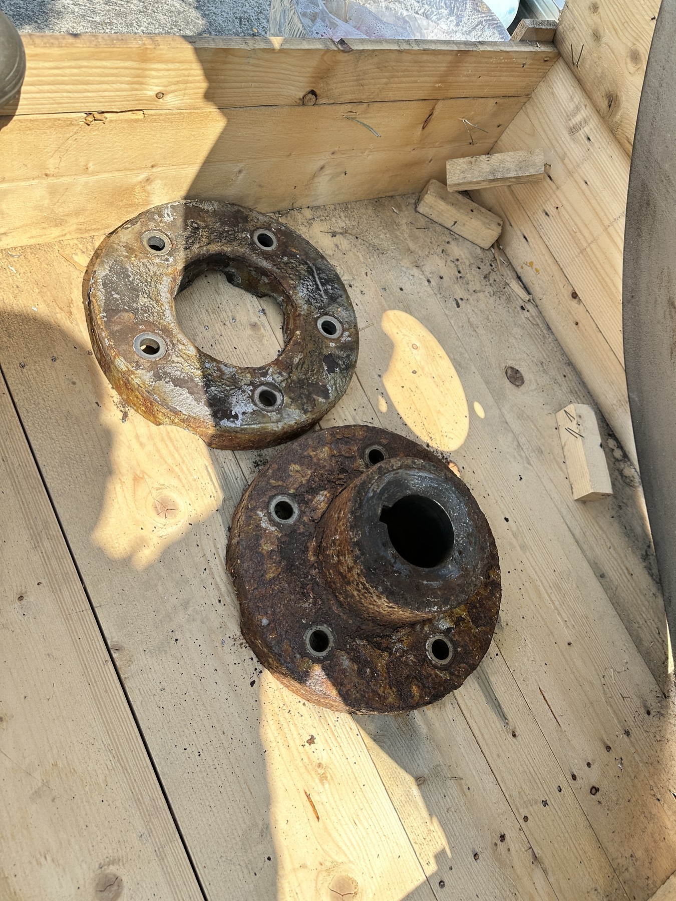 Corroded cooling-tower fan hub disc and clamp ring removed at the Ayutthaya site, laid out before refurbishment and coating