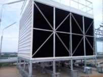 A new package cooling tower with a black air-inlet face on a steel support frame